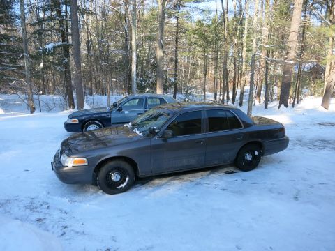 2001 Ford Crown Victoria - Photograph of two Ford Crown Victoria sedans parked in snow, not a technical document.