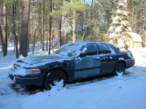2001 Ford Crown Victoria - Photograph of a blue State Police-marked Ford Crown Victoria covered in snow, not a technical document.