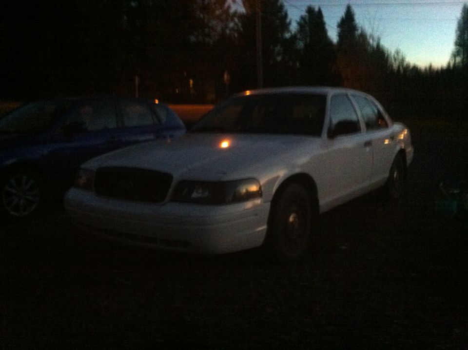 White Ford Crown Victoria sedan parked at dusk.