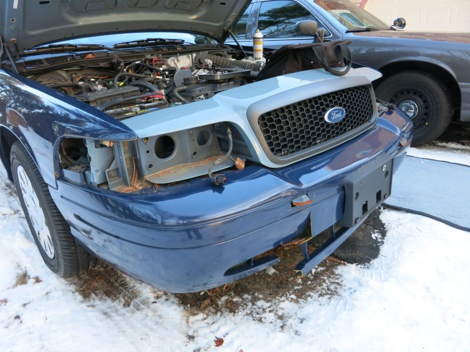 Blue Ford Crown Victoria front with hood up and bumper cover removed