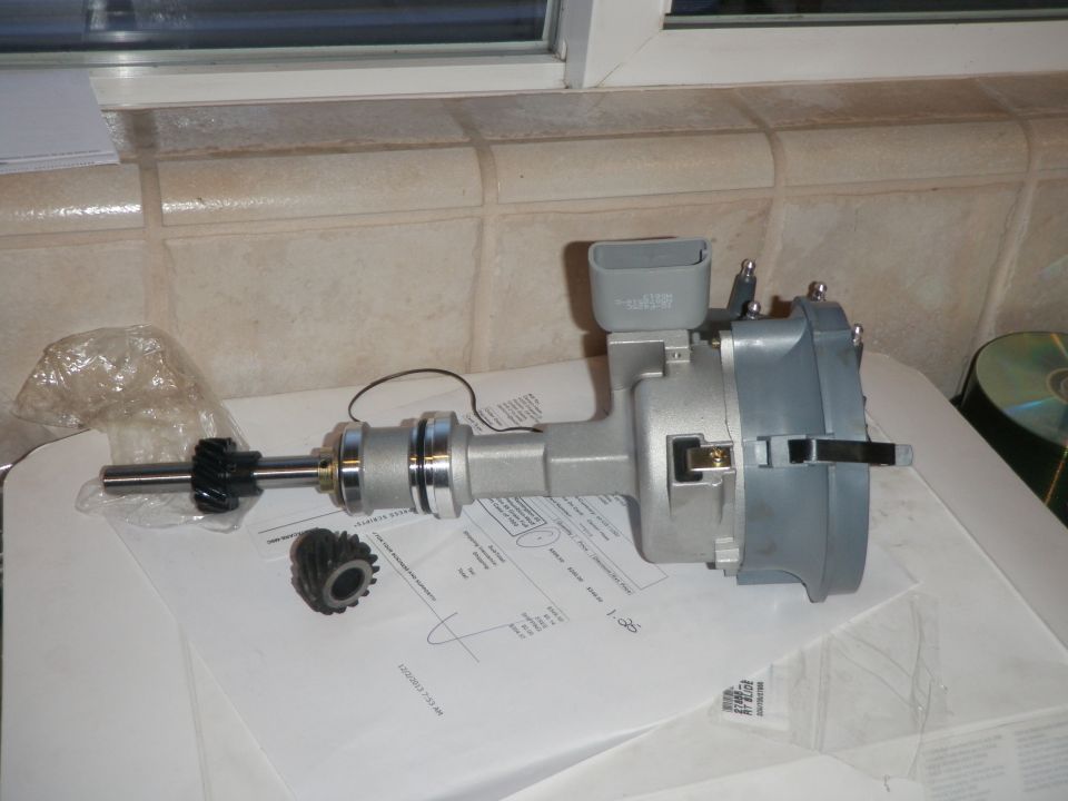 New distributor with gears on a table with papers.