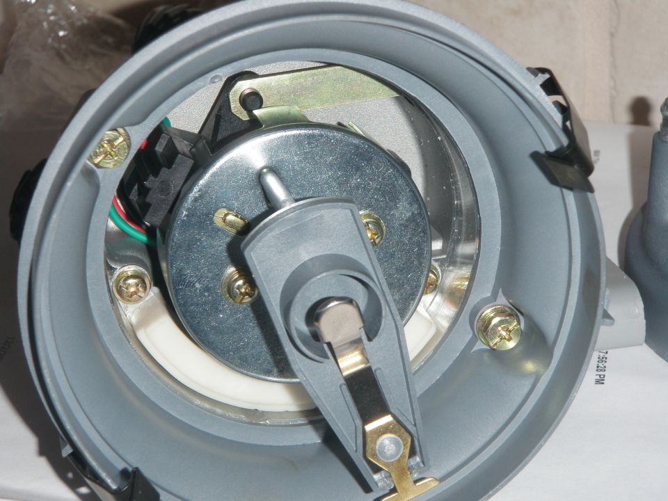 Close-up of a vehicle distributor cap interior with rotor and electronic components.