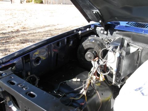 1982 Ford Bronco - The engine bay of a vehicle is shown with the hood open, revealing the engine components.