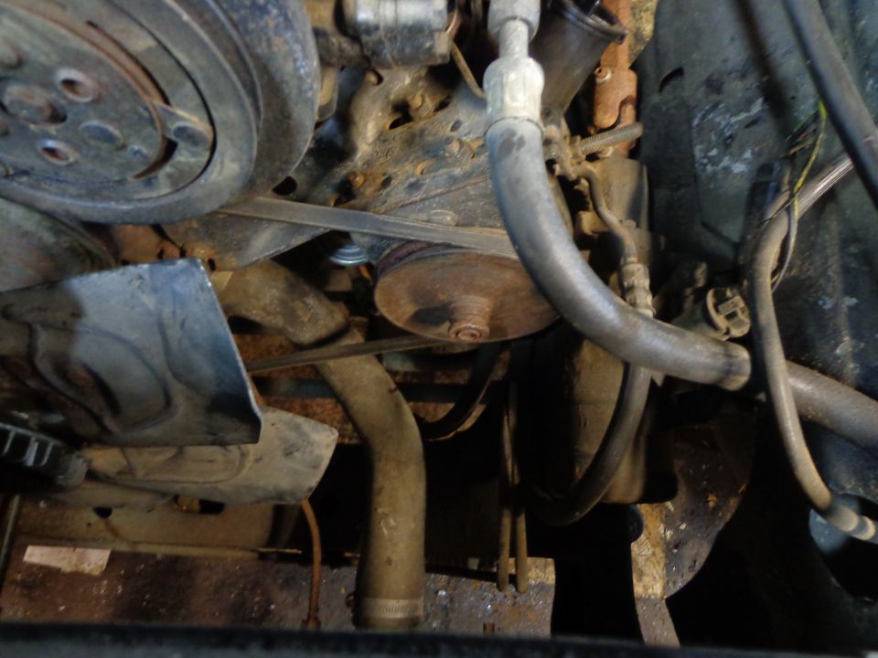 Close-up of Ford Bronco engine bay with fan, belts, and pulleys.