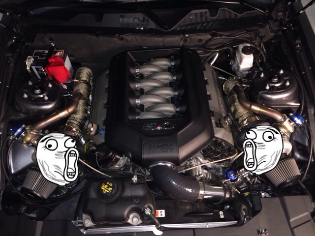 Ford Mustang engine bay with twin turbos and meme faces.