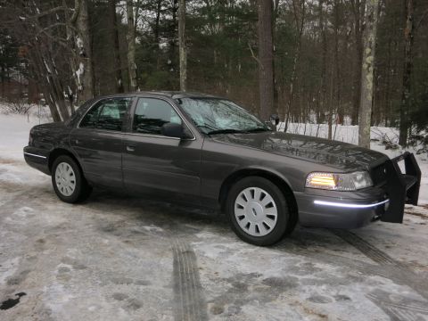 2001 Ford Crown Victoria - Photograph of a gray Ford Crown Victoria sedan parked in snow, not a technical document.