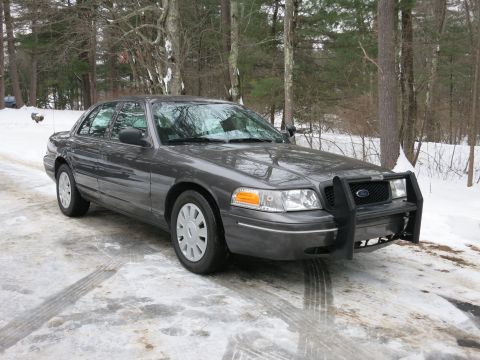 2001 Ford Crown Victoria - Photograph of a gray Ford Crown Victoria with a black push bumper in snow, not a technical document.