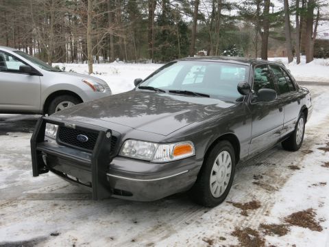 2001 Ford Crown Victoria - Photograph of a gray Ford Crown Victoria with a front push bar in a snowy lot, not a technical document.