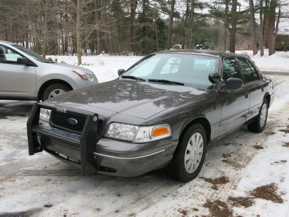 Gray Ford Crown Victoria with push bar front-quarter view in a snowy lot