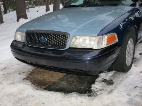 2001 Ford Crown Victoria - Close-up photograph of the front end of a blue Ford Crown Victoria, not a technical document.