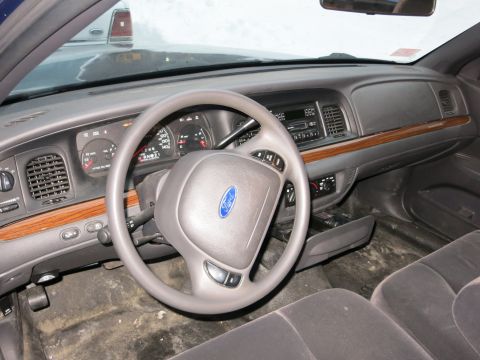 2001 Ford Crown Victoria - Photograph of a Ford Crown Victoria interior with steering wheel and instrument panel, not a technical document.