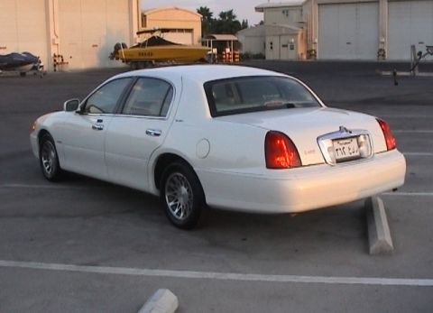 2002 Lincoln Town Car - A white 2002 Lincoln Town Car is parked at an angle, showing its rear and side profile.