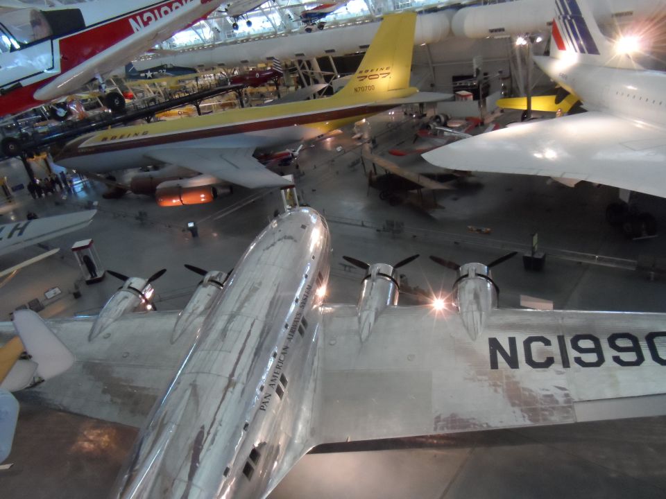Silver Pan American Airways System airplane NC1990 with propellers, indoors.