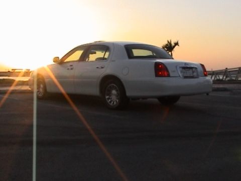 2002 Lincoln Town Car - Rear view of a white 2002 Lincoln Town Car during a sunset.