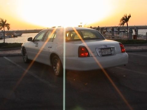 2002 Lincoln Town Car - A white 2004 Lincoln Town Car is parked by the water at sunset.