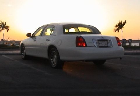 2002 Lincoln Town Car - A white 2002 Lincoln Town Car is parked outdoors during sunset, viewed from the rear.