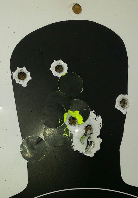 1995 Ford F-150 - A silhouette target displays numerous bullet impacts, some with bright yellow markings.