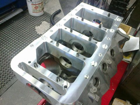 1972 Ford Ranchero - Custom aluminum engine block sits on a red stand in a workshop.