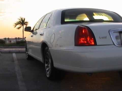 2002 Lincoln Town Car - Rear view of a white 2002 Lincoln Town Car parked outdoors during sunset.