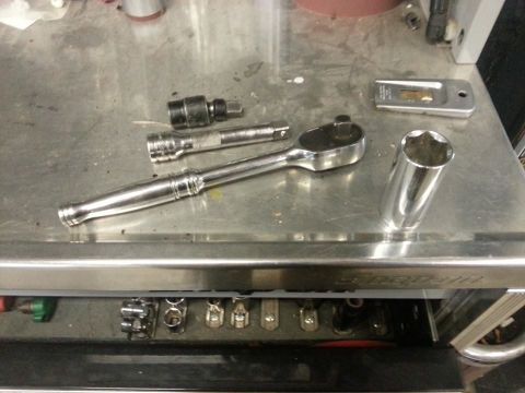 1995 Ford F-150 - Mechanic's tools including a ratchet, extension, and socket are laid out on a workbench.