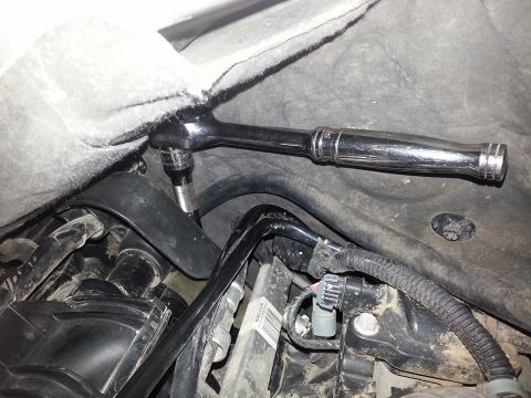 1995 Ford F-150 - Close-up view of a ratchet tool engaged with engine components, highlighting mechanical work.