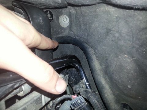 1995 Ford F-150 - A finger points to a section of the engine bay wiring harness, showing electrical connections and tubing.