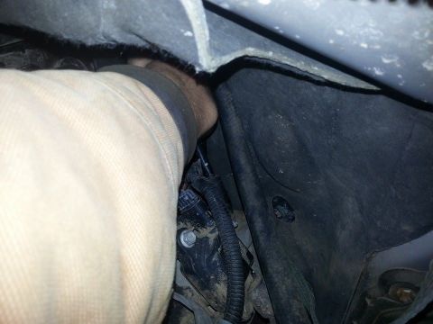 1995 Ford F-150 - A hand is working on the wiring harness in the engine bay of a vehicle.