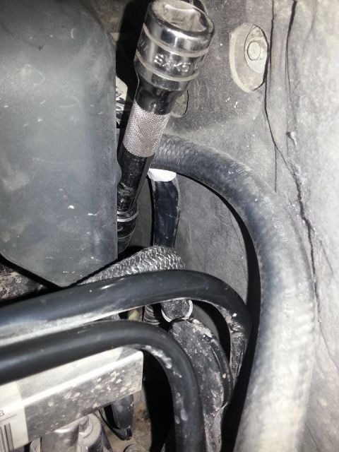 1995 Ford F-150 - Close-up of engine bay components, showing a socket wrench in use.