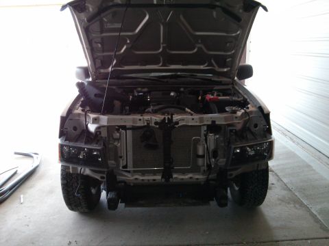 1986 Ford Bronco - The front of a truck is shown with the hood open and parts removed for repair.