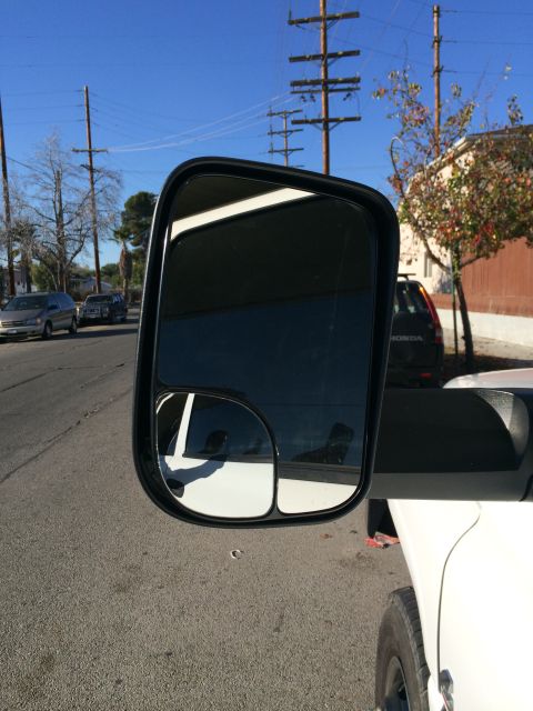 1997 Dodge 3500 - Side mirror shows reflection of a white vehicle and street scene with other cars.