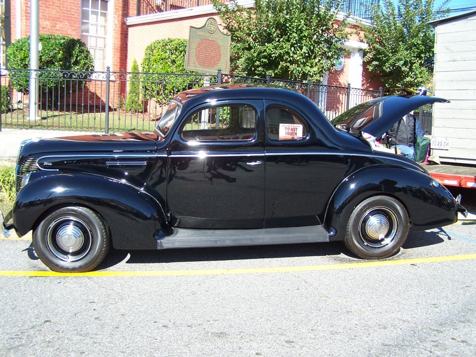 Black 1939 Ford Coupe parked on street, trunk open