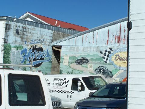 1971 Ford Ranchero - Mural on a building wall shows race cars and text related to racing history.