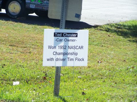 1971 Ford Ranchero - A racing vehicle is partially visible in the background behind a sign detailing Ted Chester's 1952 NASCAR Championship win.