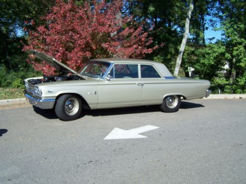1971 Ford Ranchero - A vintage champagne sedan is parked on asphalt, its hood raised to reveal the engine compartment.