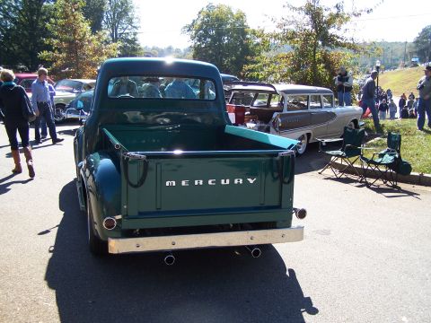 1971 Ford Ranchero - Rear view of a vintage green Mercury pickup truck, likely from the early 1950s, parked at an outdoor event.
