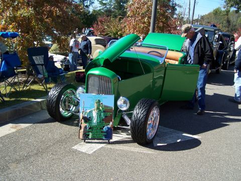 1971 Ford Ranchero - A green hot rod is displayed with its hood and door open, a descriptive board in front.