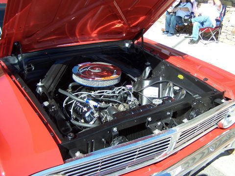 1971 Ford Ranchero - The engine bay of a red vehicle is open, revealing the motor and chrome air cleaner.