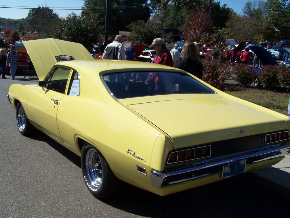 Yellow 1970s coupe utility vehicle rear view. "Ranchero" script visible