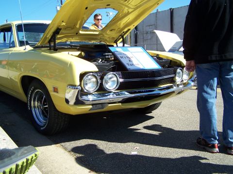 1971 Ford Ranchero - Front view of a yellow 1970 Ford pickup truck with hood open, displaying a sign.