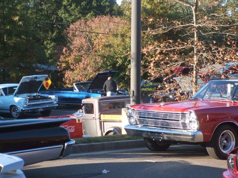1971 Ford Ranchero - A red 1965 Ford Galaxie is parked in front of other vehicles and trees.