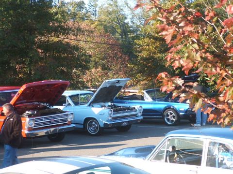 1971 Ford Ranchero - A light blue 1967 Ford Ranchero convertible is displayed with its hood open, alongside other classic vehicles at an outdoor event.
