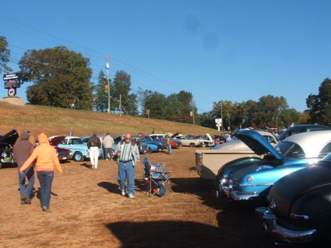 1971 Ford Ranchero - Attendees mill around a collection of vintage automobiles at an outdoor gathering.
