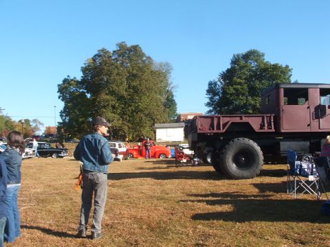1971 Ford Ranchero - A large military truck is parked at an outdoor event with several other vehicles visible.