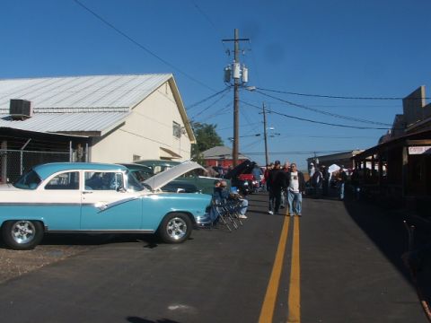 1971 Ford Ranchero - Classic car show scene with multiple vehicles and attendees on a sunny day.
