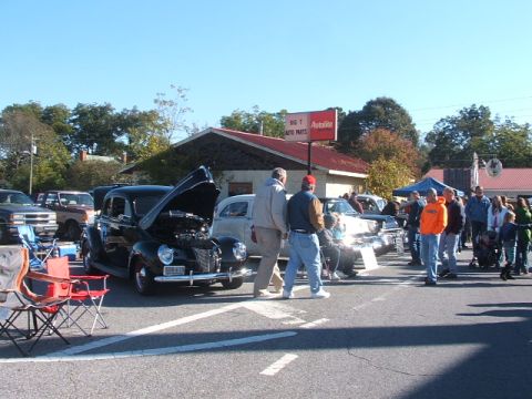 1971 Ford Ranchero - A black coupe from the 1940s is displayed with its hood open at an outdoor car show.