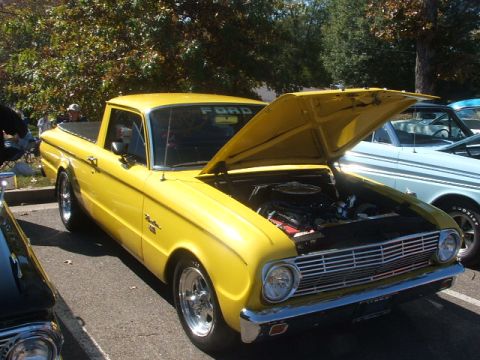1971 Ford Ranchero - A bright yellow 1971 Ford Ranchero is displayed with its hood open, revealing the engine compartment.