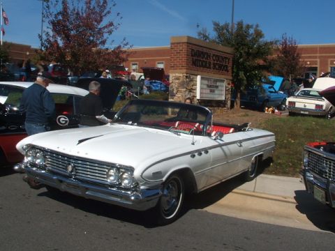 1971 Ford Ranchero - A white convertible is parked at an outdoor car show in front of Dawson County Middle School.