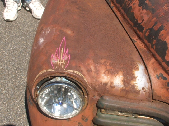 Rusted fender with pinstripe flame graphic and headlight