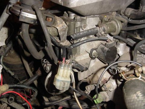 1992 Ford Bronco - Close-up view of engine components, including fuel lines and electrical connectors, with visible text on a fuel hose.