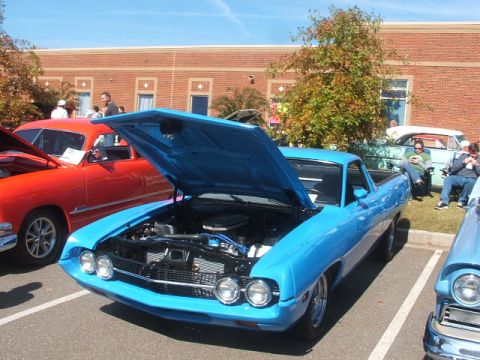 1971 Ford Ranchero - A bright blue pickup truck is displayed with its hood open, revealing the engine compartment.